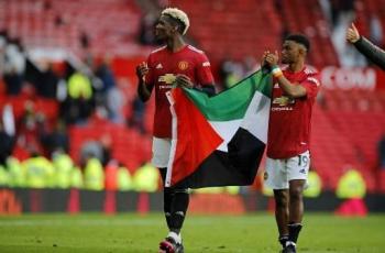 Paul Pogba dan Amad Diallo kibarkan bendera Palestina. (PHIL NOBLE / POOL / AFP)
